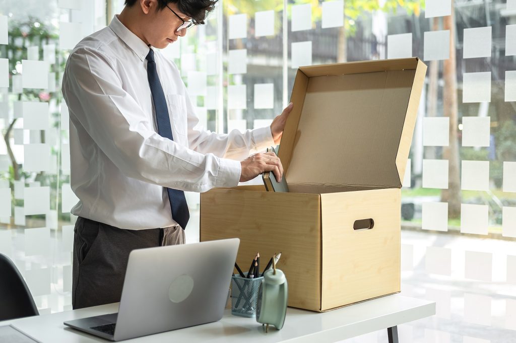 man carrying box out of office