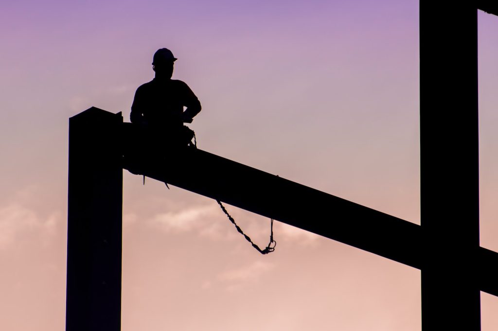 person sitting on top of construction beam